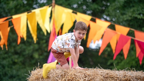 A child climbs Strawton Castle in the play meadow at Stourhead